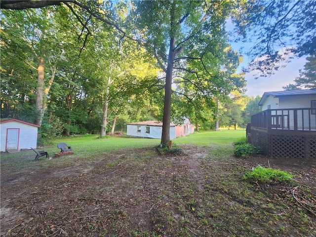 view of yard with a storage shed and a deck