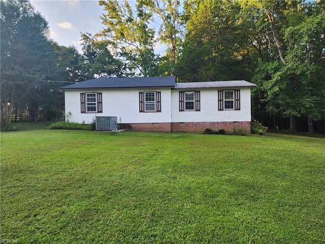 manufactured / mobile home with a front lawn and central air condition unit