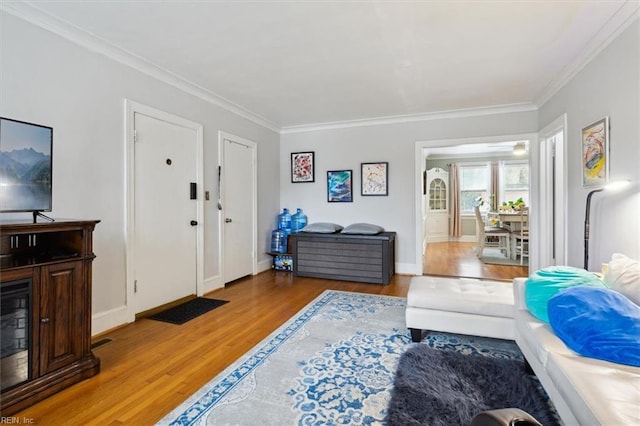 living room featuring light hardwood / wood-style flooring and crown molding