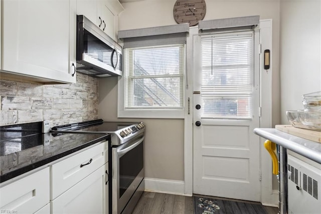 kitchen featuring white cabinets, appliances with stainless steel finishes, plenty of natural light, and dark hardwood / wood-style flooring