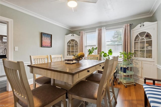 dining space featuring ceiling fan, crown molding, and wood-type flooring