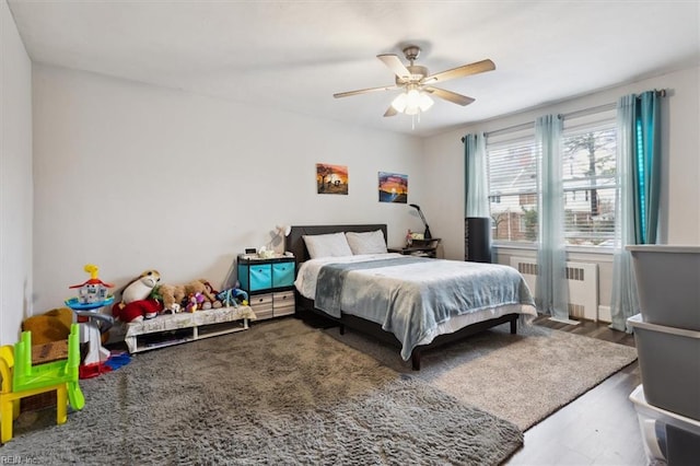 bedroom featuring radiator, ceiling fan, and wood-type flooring