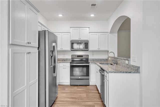 kitchen featuring light hardwood / wood-style floors, appliances with stainless steel finishes, sink, and white cabinetry