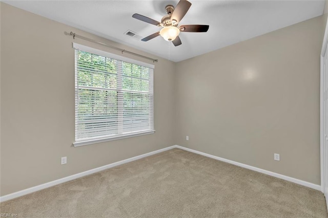 carpeted spare room featuring ceiling fan