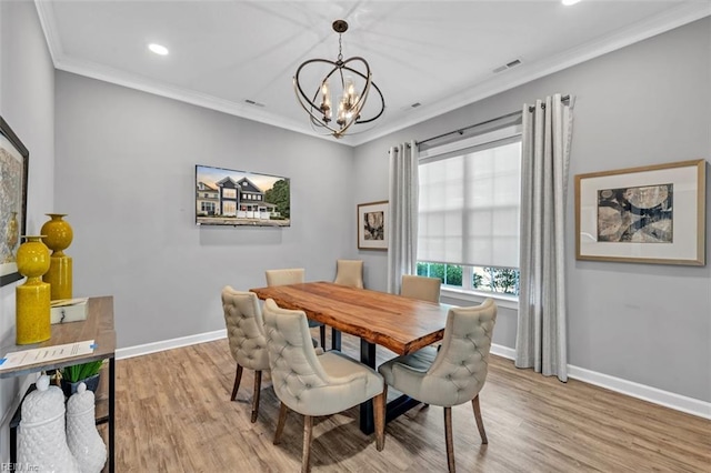 dining area with crown molding, light hardwood / wood-style floors, and a chandelier