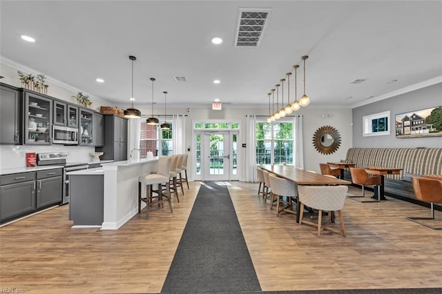 dining area with light hardwood / wood-style flooring and ornamental molding