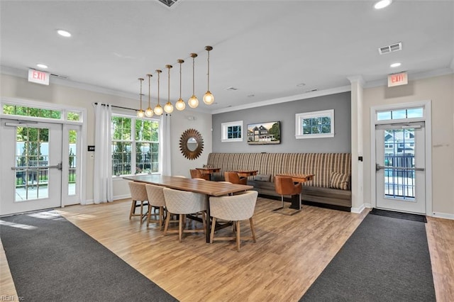 dining area featuring light wood-type flooring and ornamental molding