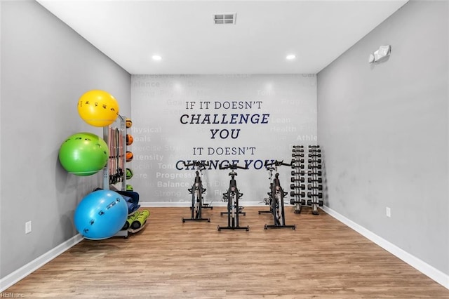 exercise room with hardwood / wood-style floors