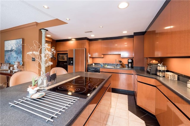 kitchen featuring light tile patterned floors, sink, ornamental molding, black appliances, and ornate columns