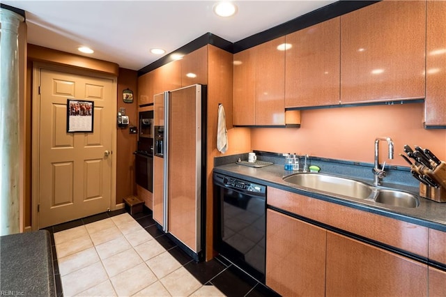 kitchen featuring ornate columns, black appliances, light tile patterned flooring, and sink