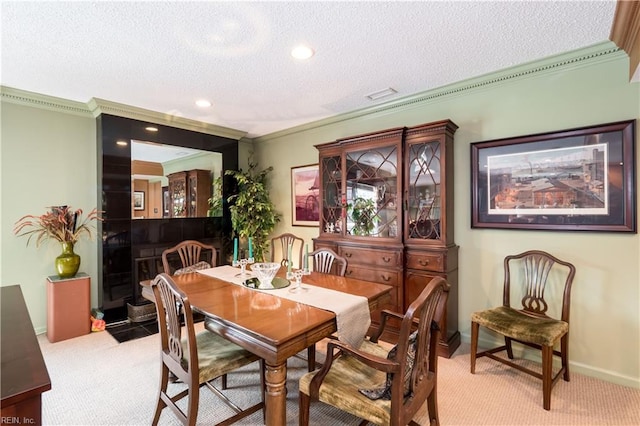 carpeted dining room with a textured ceiling and crown molding