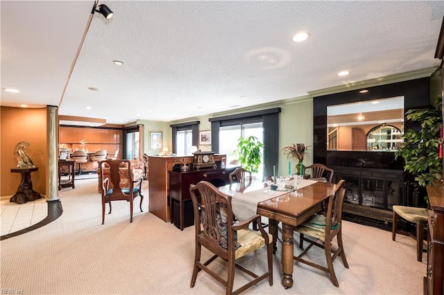 dining area featuring a textured ceiling, light colored carpet, and crown molding