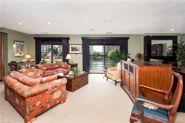 living room with light carpet, ornamental molding, a textured ceiling, and a healthy amount of sunlight