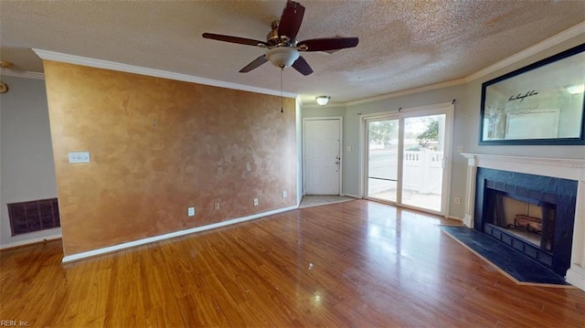 unfurnished living room featuring ceiling fan, hardwood / wood-style flooring, ornamental molding, and a textured ceiling