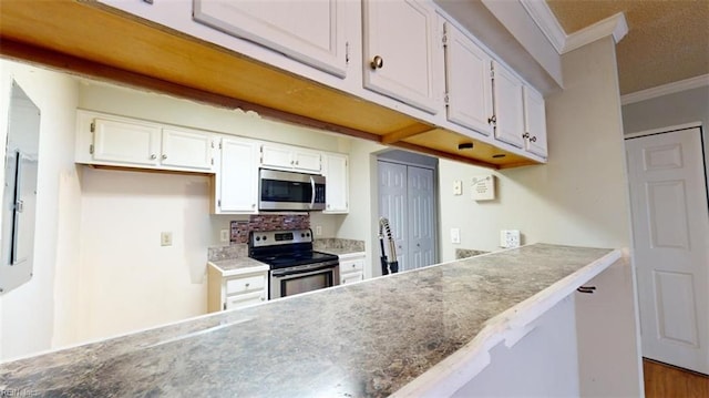 kitchen featuring white cabinetry, appliances with stainless steel finishes, hardwood / wood-style floors, and crown molding