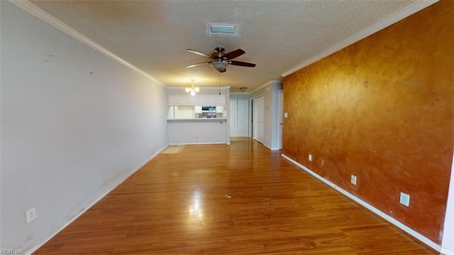 unfurnished room featuring ceiling fan with notable chandelier, wood-type flooring, a textured ceiling, and crown molding