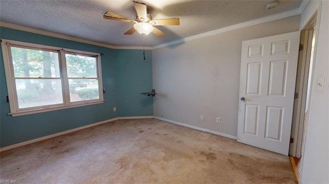 carpeted spare room featuring ceiling fan, a textured ceiling, and crown molding