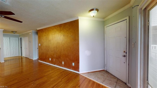 foyer featuring light wood-type flooring, crown molding, a textured ceiling, and ceiling fan