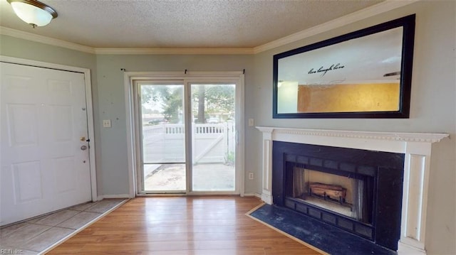 interior space with a textured ceiling, hardwood / wood-style floors, and crown molding