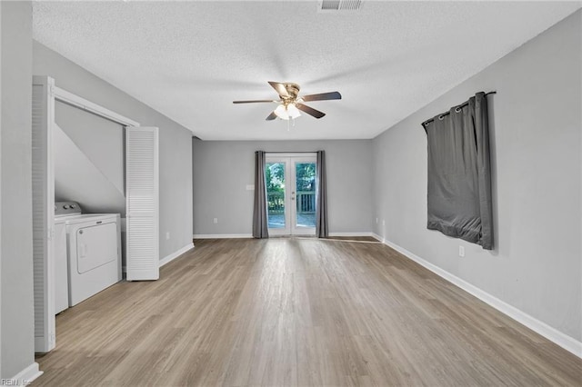 unfurnished living room with ceiling fan, separate washer and dryer, a textured ceiling, and light hardwood / wood-style floors