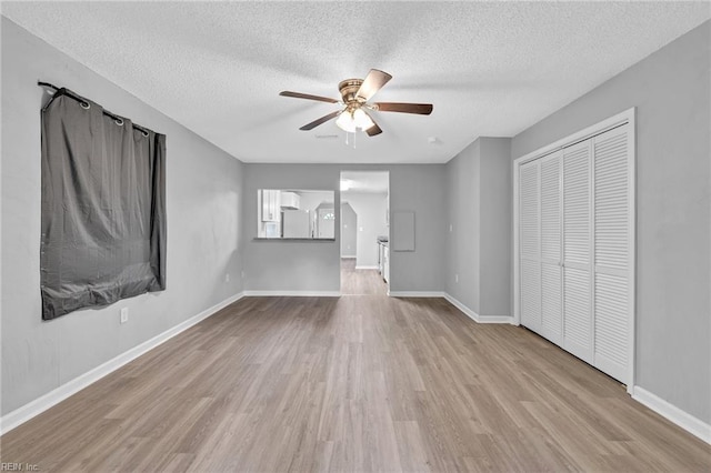 interior space featuring a closet, light wood-type flooring, ceiling fan, and a textured ceiling