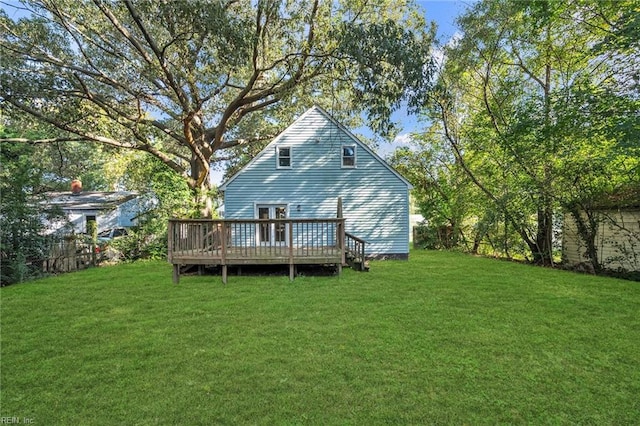 rear view of house with a wooden deck and a lawn