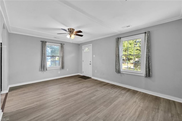 unfurnished room with wood-type flooring, ornamental molding, ceiling fan, and plenty of natural light