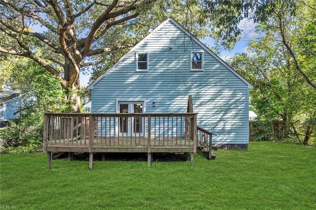 rear view of property featuring a wooden deck and a lawn