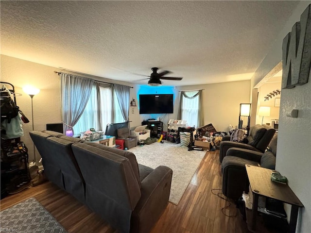 living room with ceiling fan, hardwood / wood-style flooring, and a textured ceiling