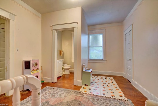 bedroom featuring connected bathroom and hardwood / wood-style flooring