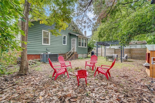 view of yard with cooling unit, a fire pit, and a pergola