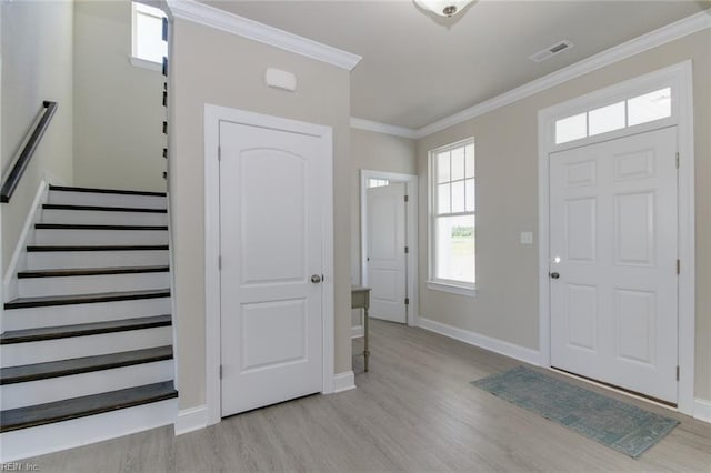 entryway featuring crown molding and light wood-type flooring