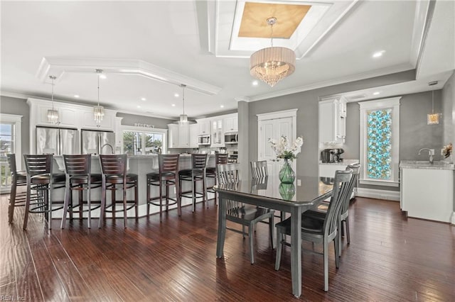 dining room with a notable chandelier, crown molding, dark hardwood / wood-style flooring, and sink