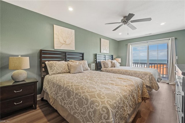 bedroom featuring a water view, dark hardwood / wood-style flooring, ceiling fan, and access to exterior