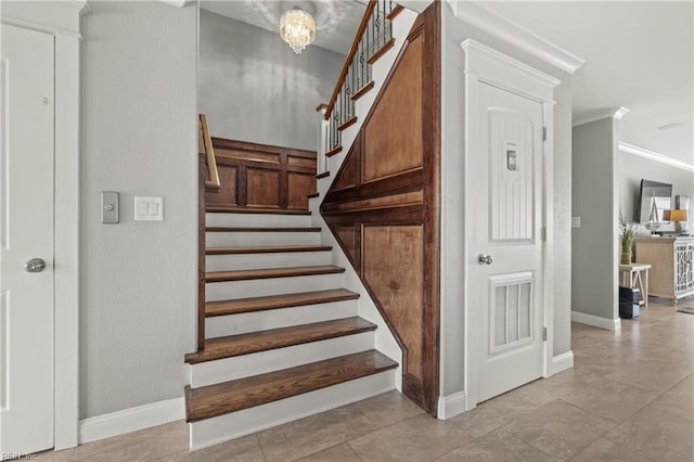 staircase with a notable chandelier and crown molding