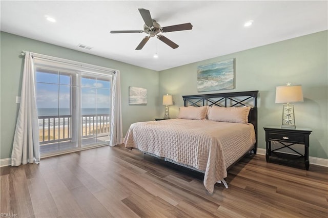 bedroom featuring a water view, ceiling fan, and hardwood / wood-style flooring