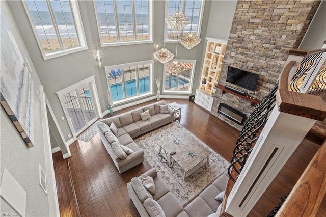 2816 Sandfiddler Rd, Virginia Beach, VA 23456 - living room featuring a stone fireplace, wood finished floors, healthy amount of natural light, a high ceiling, and baseboards
