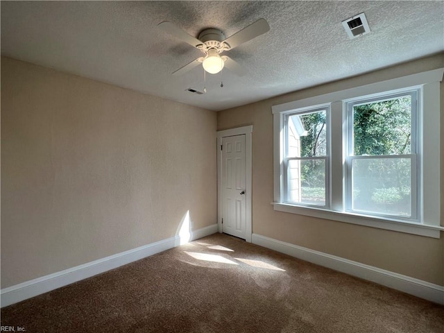 carpeted spare room featuring a textured ceiling and ceiling fan