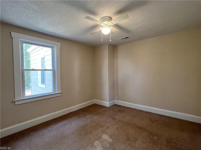 carpeted empty room with ceiling fan and a textured ceiling