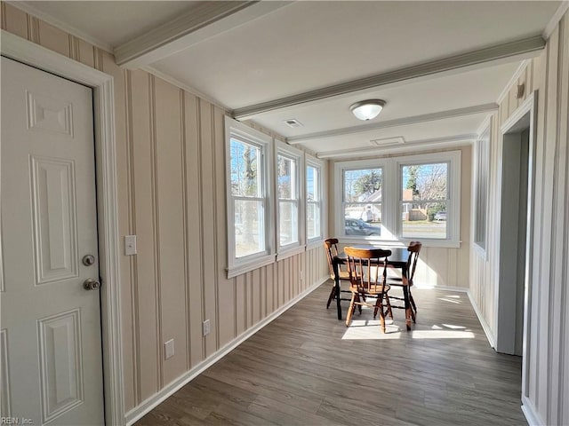 dining space with beamed ceiling and dark wood-type flooring