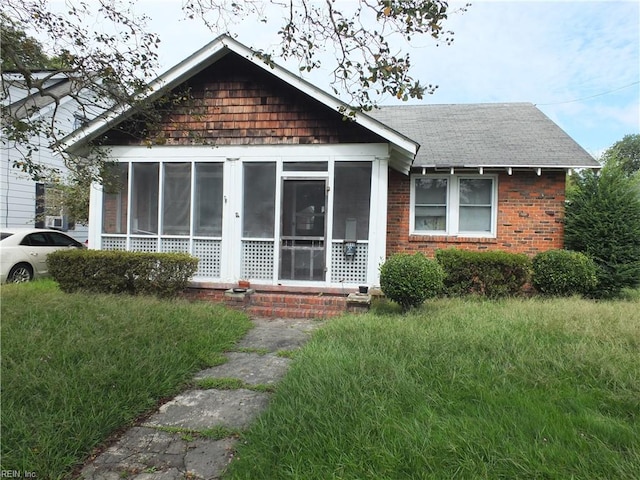 view of front of house with a front yard and a sunroom