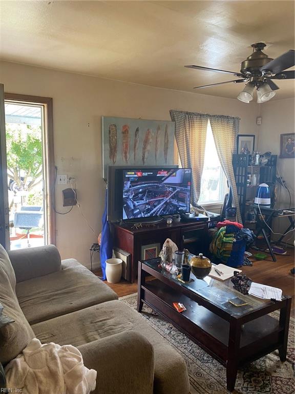 living room featuring hardwood / wood-style floors and ceiling fan