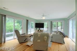 living room featuring ceiling fan and light hardwood / wood-style flooring