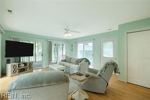 living room featuring light hardwood / wood-style flooring and ceiling fan