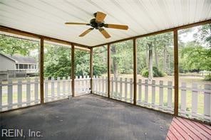 unfurnished sunroom with wood ceiling, ceiling fan, and plenty of natural light