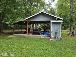 view of outdoor structure with a carport and a yard