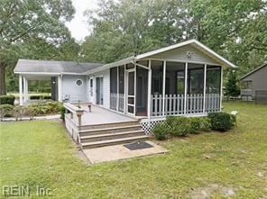 back of property featuring a sunroom and a yard