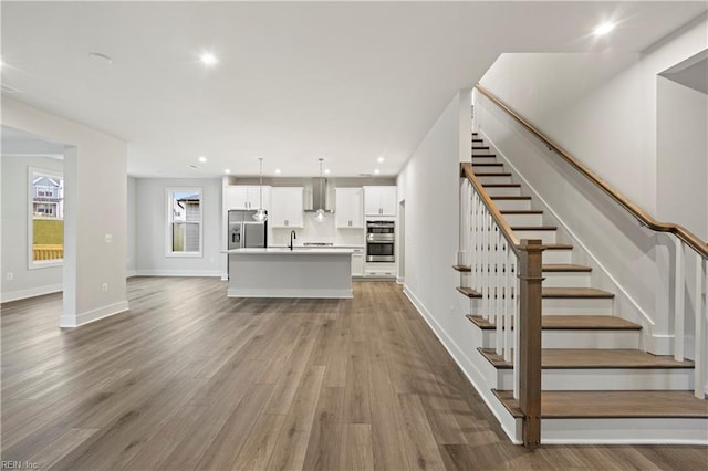 unfurnished living room featuring hardwood / wood-style floors and sink