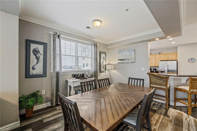 dining area featuring dark wood-type flooring and crown molding