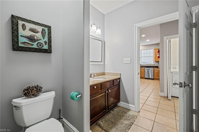 bathroom with vanity, toilet, washer / dryer, and tile patterned floors